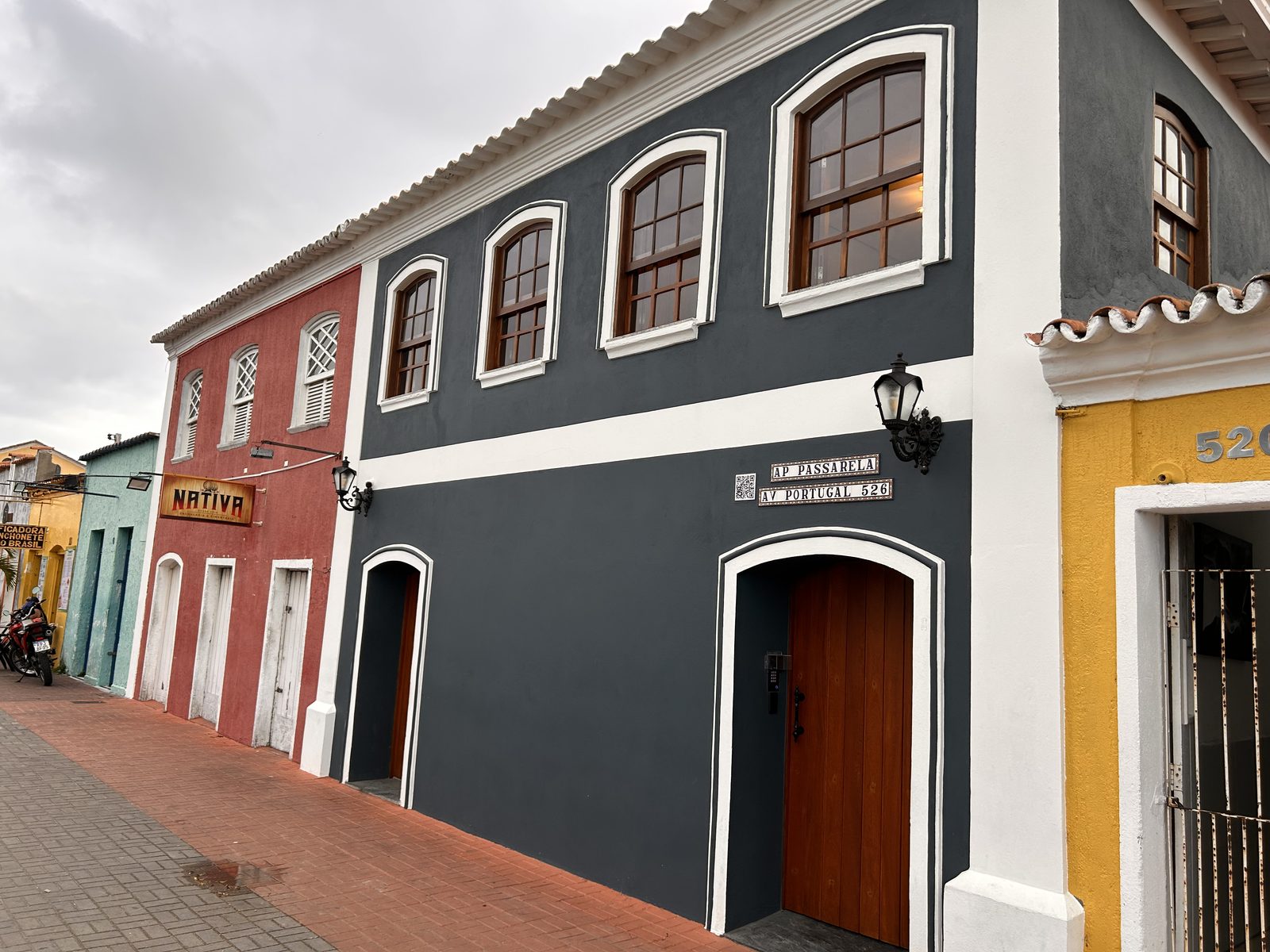 O prédio do AP Passarela na Avenida Portugal, com o calçadão da Passarela da Cultura e as casas coloridas seguindo rua adentro