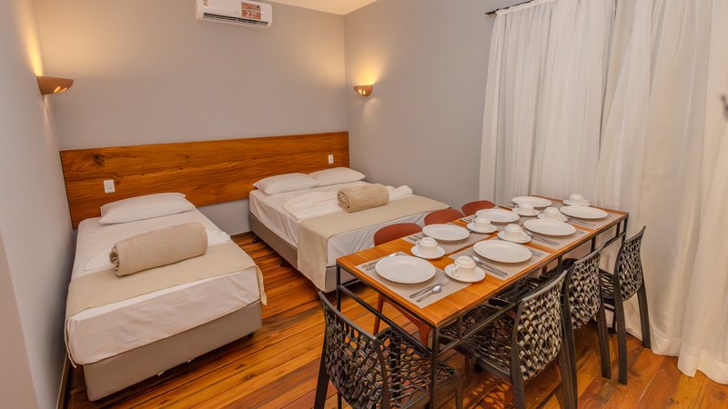 Superior Família para 7 pessoas, com as camas de um lado e a mesa grande do outro